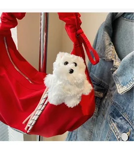 Detailed shot of a red pleated cloud bag with a white plush dog pendant accessory