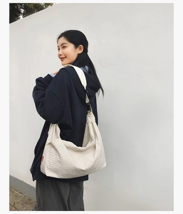 Detailansicht der cremefarbenen Hobo-Tasche mit Textur und breitem Schultergurt