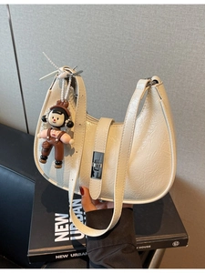 Chic cream white pleated patent leather Hobo bag with silver buckle and plush charm