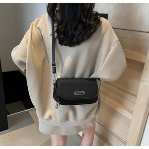 Détail d'un sac bandoulière noir grainé avec plaque métallique argentée Fashion
