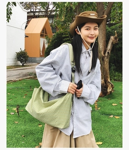 Outdoor-Lifestyle-Aufnahme einer großen hellgrünen Canvas-Umhängetasche für Damen