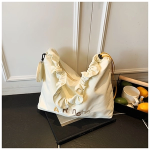 Détail du sac cabas crème avec volants, cordon jaune et porte-monnaie amovible