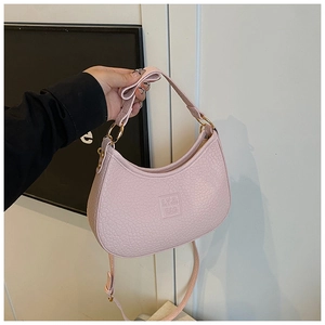 Detail of pink crescent bag with pebble leather texture and metal ring buckle design