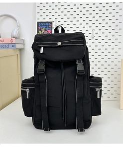 Detailed close-up of a black nylon hiking backpack with multiple pockets and secure buckles
