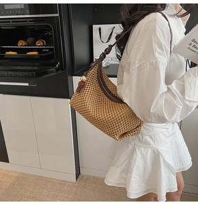 Détail du sac en paille tressée avec bandoulière marron foncé et perles décoratives
