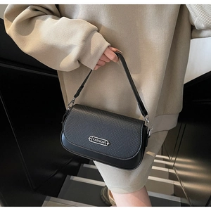Détail du sac à main noir avec rabat tissé et plaque métallique argentée FASHION élégante