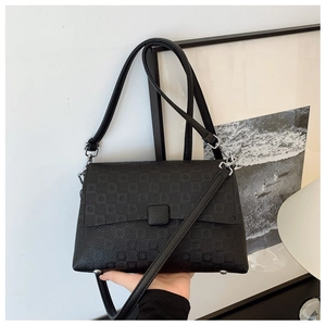 Detail shot of black crossbody bag featuring pebble leather texture and checkered pattern