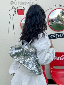 Silver sequin shoulder tote bag with large capacity and shiny metallic finish outdoors