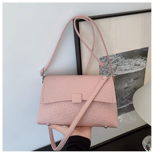 Detail of pink crossbody bag featuring geometric texture and protective base studs