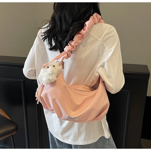 Pink nylon crossbody bag detail with pleated shoulder strap and plush lamb charm