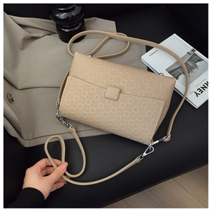 Detail of beige checkered embossed leather shoulder bag with adjustable silver buckle strap