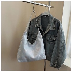 Sac fourre-tout bleu clair avec broderie papillon et texture de soie sur veste en jean