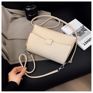 Detail of beige embossed leather shoulder bag with a square buckle on a stylish setup