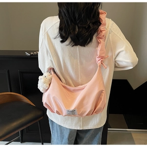 Detailed back view of pink hobo shoulder bag with ruched strap and plush charm detail