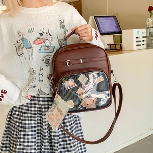 Détail du sac à dos marron en PU avec fenêtre transparente et peluches décoratives