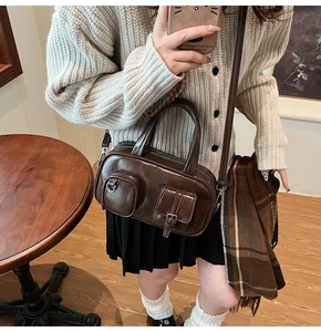 Detail of vintage dark brown faux leather crossbody bag with functional front pockets