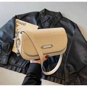 Détail du sac beige avec texture tressée en paille et plaque métallique FASHION