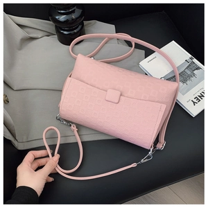 Detail of pink embossed rectangular shoulder bag with silver hardware on chic set