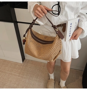 Détail du sac bandoulière en paille tressée avec bandoulière en cuir brun et fermeture