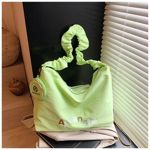 Détail du sac à bandoulière plissé vert fluo avec porte-monnaie rond assorti et broderie