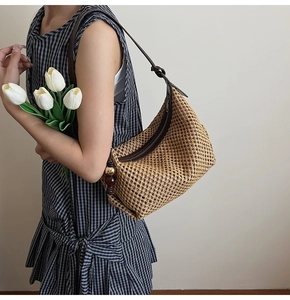 Détail du sac à bandoulière en paille tressée avec breloque perlée et cuir marron