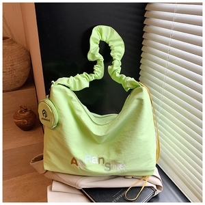 Détail du sac fourre-tout vert fluo plissé avec broderie et mini pochette assortie