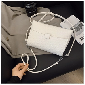Detailed top view of white faux leather crossbody bag with heart embossed texture