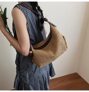Détail du sac hobo en paille tressée avec bandoulière cuir et billes dorées