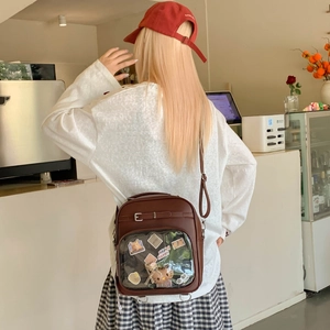 Vue détaillée du sac Ita marron avec fenêtre PVC transparente et bretelles réglables