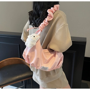 Pink pleated dumpling bag with cloud strap and white plush cat charm detail view