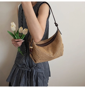 Détails du sac hobo en paille tressée marron avec bandoulière en cuir et pendentif perlé