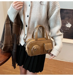 Detailed side view of vintage caramel leather pillow bag with dual front pockets