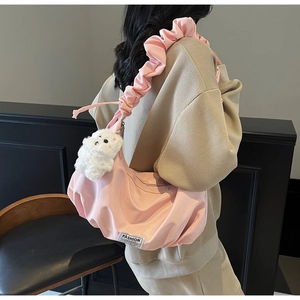 Pink nylon shoulder bag featuring pleated strap and cute white plush dog charm detail