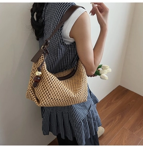 Détail du sac à bandoulière en paille tissée avec glands en cuir et perles dorées