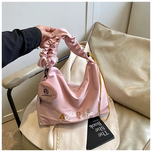 Vue détaillée du sac hobo rose avec poignée plissée et accents de cordon jaune