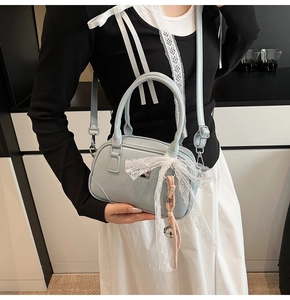 Detail der hellblauen Mini-Bowlingtasche mit Spitzenschleife und geflochtener Glocke