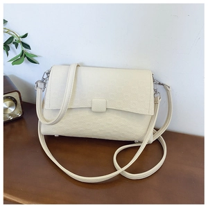 Detail showing vintage off-white faux leather shoulder bag with embossed texture