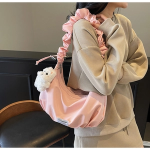 Pink pleated dumpling bag with ruffled strap and a cute white bear pendant accessory