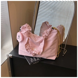 Vue détaillée du sac cabas plissé rose avec petit pendentif rond et broderie Rare