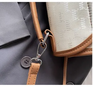 Détail du crochet en métal argenté et bandoulière en cuir sur sac à dos étanche