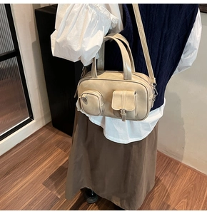 Detail view of beige crossbody bag with multi-pocket utility design and sleek faux leather