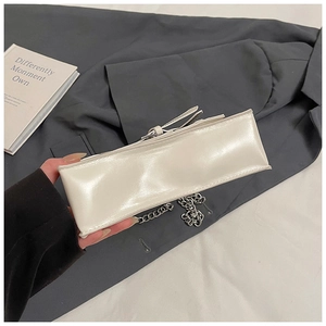 Detail shot of off-white minimalist square bag with silver chain and smooth faux leather