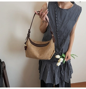 Détail du sac en paille tressée avec bandoulière en cuir noué et breloque en perles