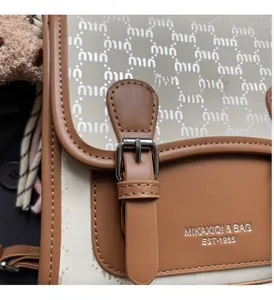 Détail du tissu jacquard à monogramme avec boucle argentée haut de gamme sur un sac à main