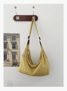Detail der gelben karierten Hobo-Tasche mit weicher Textur und verstellbarem Gurt