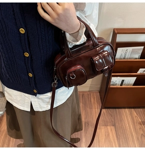 Detailed close-up of dark brown glossy leather vintage satchel with multi-pocket design