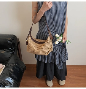 Détail d'un sac hobo tissé à la main avec bandoulière en cuir et breloque sphérique