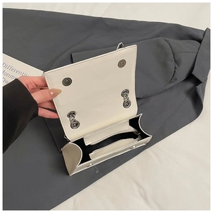 Detailed view of white crossbody bag interior with silver magnetic closure and compartments