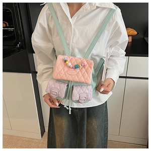Rear view of a model wearing the quilted pastel macaron colorblock backpack in a kitchen