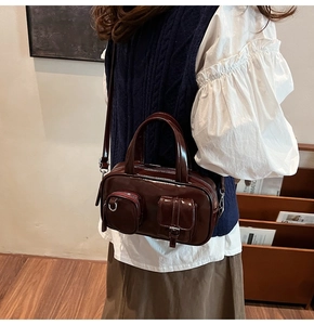 Retro deep brown leather crossbody bag styled with white puff sleeves and navy knit vest